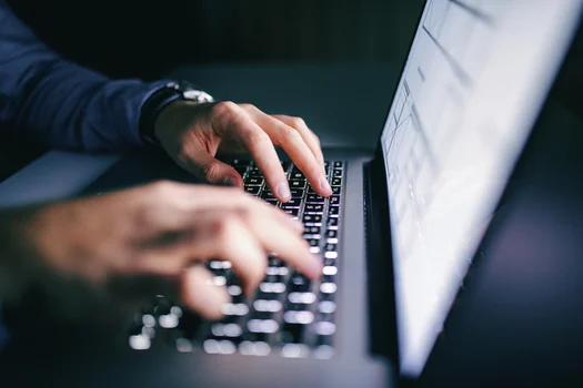 close-up of two hands typing on a keyboard